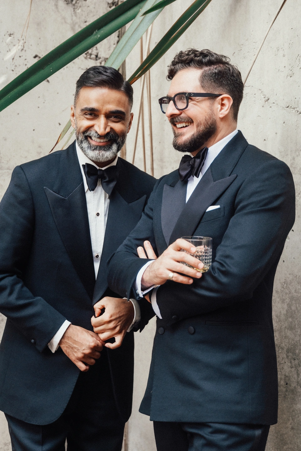 Two men share a joke wearing tuxedos for their black tie event