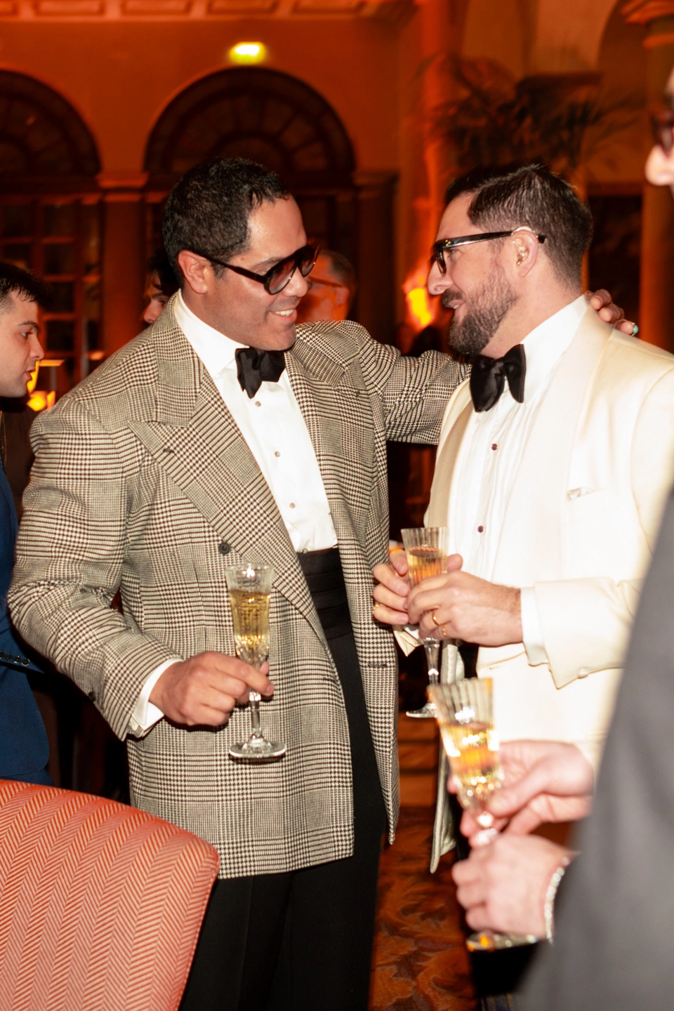 two men wear black tie at a drinks reception