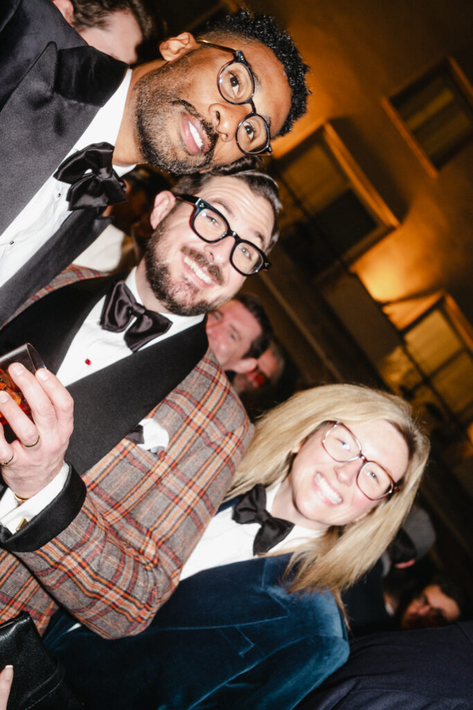 people smiling wearing black tie at a party