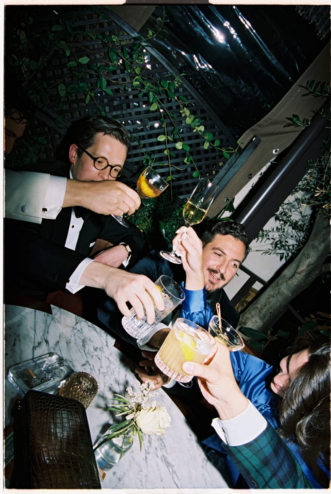 Guest raises their drinks and cheers at a black tie dinner