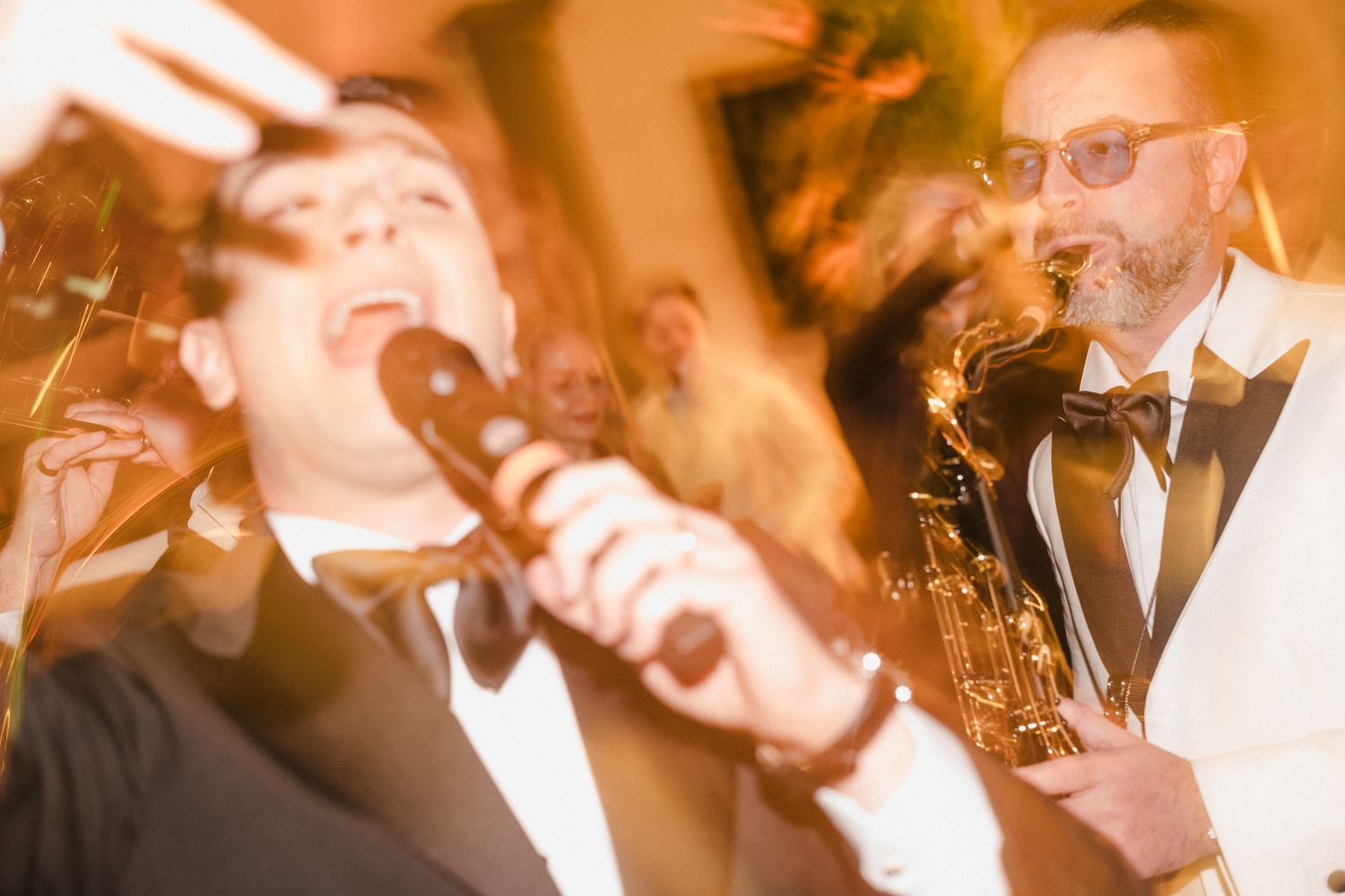 Musicians playing music and signing at a black tie dinner party